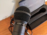 Close-up of the black Sapporo S228 microphone head showing the metal mesh grille and 'UNI-DIRECTIONAL' label on the body.