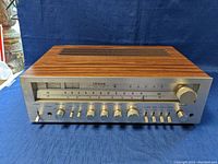 Front view of the Citizen JS6330 receiver showing wood grain casing and metal control panel with meters and knobs.