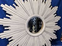 Front view of the full sunburst mirror against a blue backdrop