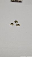 Three oval faceted light champagne colored Cambodian zircon gemstones displayed on a white background.