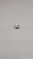 Oval cut natural aquamarine (goshenite) gemstone pictured on white background, showing top facets and luster.