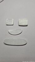 Four cut and polished natural selenite stones arranged on white background, showing different sizes and shapes.