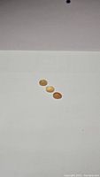 Three peach moonstone cabochons laid flat on a white surface, showcasing their oval shapes and peach color variations.