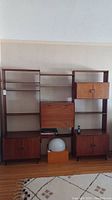 Full frontal view of assembled three-section teak wall unit against wall