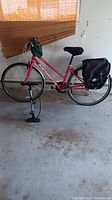 Full side view of pink Norco bike with panniers, handlebar bag and pump
