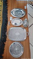 Overhead photo of all silver plated serving pieces arranged on floor showing variety and details of each item