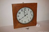 Front view of oak case clock with key laid on table
