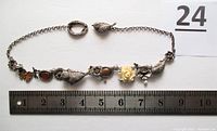 Full view of the necklace laid next to a 10 cm ruler showing the entire 17 inch length and clasp details.