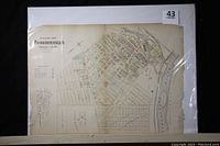 Overall view of both map plates inside protective sleeve, showing map details and size.