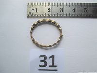 Top view of bamboo-style sterling silver bracelet with gold wash next to a ruler showing size and a lot number card