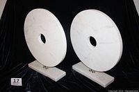 Front view of two large marble decorative rings with bases, showing size and markings.