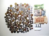 Top view of collection showing coins and paper money including Mexican currency and other international coins.