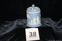 Blue and white jasperware Wedgwood lidded dresser jar on black fabric background with lot number card
