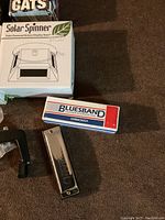 Close-up photo of a Bluesband harmonica with its box, solar spinner box partially visible.