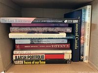 Stack of Canadian photography and nature books shown from a side angle highlighting titles and thickness.