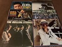 Photo showing five vintage vinyl record albums including Elvis Presley, The Rolling Stones, Elton John, Del Wood, and Johnny Cash.