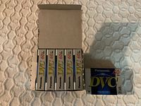 Six Panasonic DVC 60-minute digital video cassettes in original packaging, with one cassette outside the box.