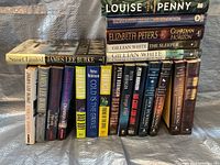 Photo of the full set of murder mystery books showing spines of 21 titles by various authors including Louise Penny, Elizabeth Peters, Peter Robinson, James Lee Burke, John Dunning, P.D. James, Gillian White.