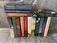 Full front view of 15 hardcover Philippa Gregory first edition books stacked side by side showing spines and titles.