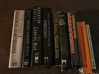 Front view of 9 books including various Robertson Davies titles: The Papers of Samuel Marchbanks, Murder on the Walking Spirits, The Cunning Man, The Lyre of Orpheus, The Manticore, Fifth Business, The Rebel Angels, World of Wonders, and Tempest-Tost.