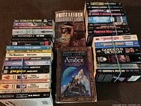 Full view of the collective lot of science fiction and fantasy books arranged side by side on a flat surface, showcasing the covers and spines for clear title identification.