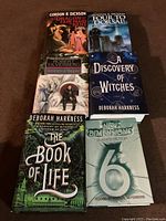 Six sci-fi fantasy books arranged on a brown background, showing titles and cover art.
