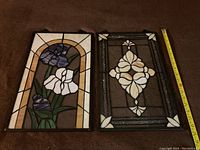 Full view of two stained glass panels side by side with measuring tape showing height