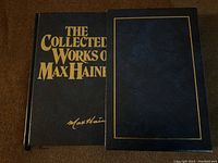 Front cover of "The Collected Works of Max Haines" blue hardcover book with gold printing and signature.