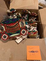 Photo of box containing two colorful vintage-style Christmas carousel music boxes, needing cleaning.