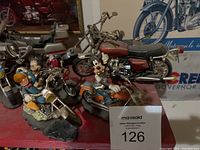 Front view of all five motorcycle figurines on red surface