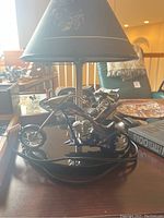 Close-up photo of black chopper motorcycle lamp base with Harley Davidson theme.