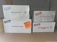 Four white boxes labeled 1958 Packard Hawk, 1951 Mercury Custom, 1957 Studebaker Custom and 1963 Coca-Cola Corvette Pro Mod