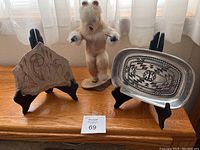 Photo showing Wilton Armetale metal bread tray, Native American rock carving on stand, and Kachina dancing figure on wooden surface.