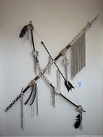 Photo showing the Native American style decorative spear, bow, and arrow mounted on a wall.