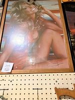 Framed Farrah Fawcett large poster in light wood frame showing her sitting with a smile, some glare on poster.