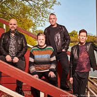 Four members of Barenaked Ladies posing outdoors