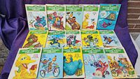 Photo showing all 15 Sesame Street Library books from 1979, arranged on a purple cloth, front covers visible.