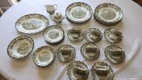 Full set of 48 Ridgeway Heritage dishes arranged on white tablecloth, assorted plates, cups, pitchers and bowls visible.