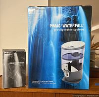 Front view of both boxed items side by side: main system and replacement filter.