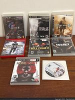 Photo showing all 7 PS3 games including cases and disc sleeves.
