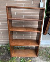 Front view of wooden bookshelf showing four shelves and overall condition
