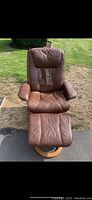 Front view of brown leather Palliser chair with matching stool showing overall condition.