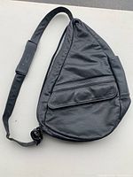 Front view of black leather AmeriBag backpack with front zippered pocket and padded strap section