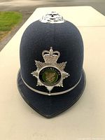 Front view of navy blue police helmet with Lincolnshire Police badge and silver crown on top.