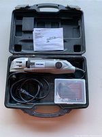 ROK oscillating multi tool inside case with power cord, accessory box, and instruction manual visible