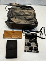 All 4 items visible: large black Vogart Rock purse, tan leather wallet, smaller black item, and cat face fabric phone carrier.