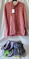 Pink striped hoodie hanging with two pairs of sandals in front, showing overall lot content