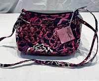 Front view of Vera Bradley Katalina Pink crossbody purse showing the quilted floral pattern, metal logo plate, flower zipper pull and attached tags.
