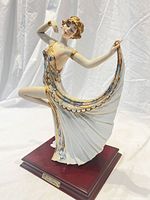 Front view of porcelain dancing girl figurine on wooden base