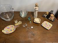 Full lot overview showing various ceramic, glass, and decorative items on a wooden surface.